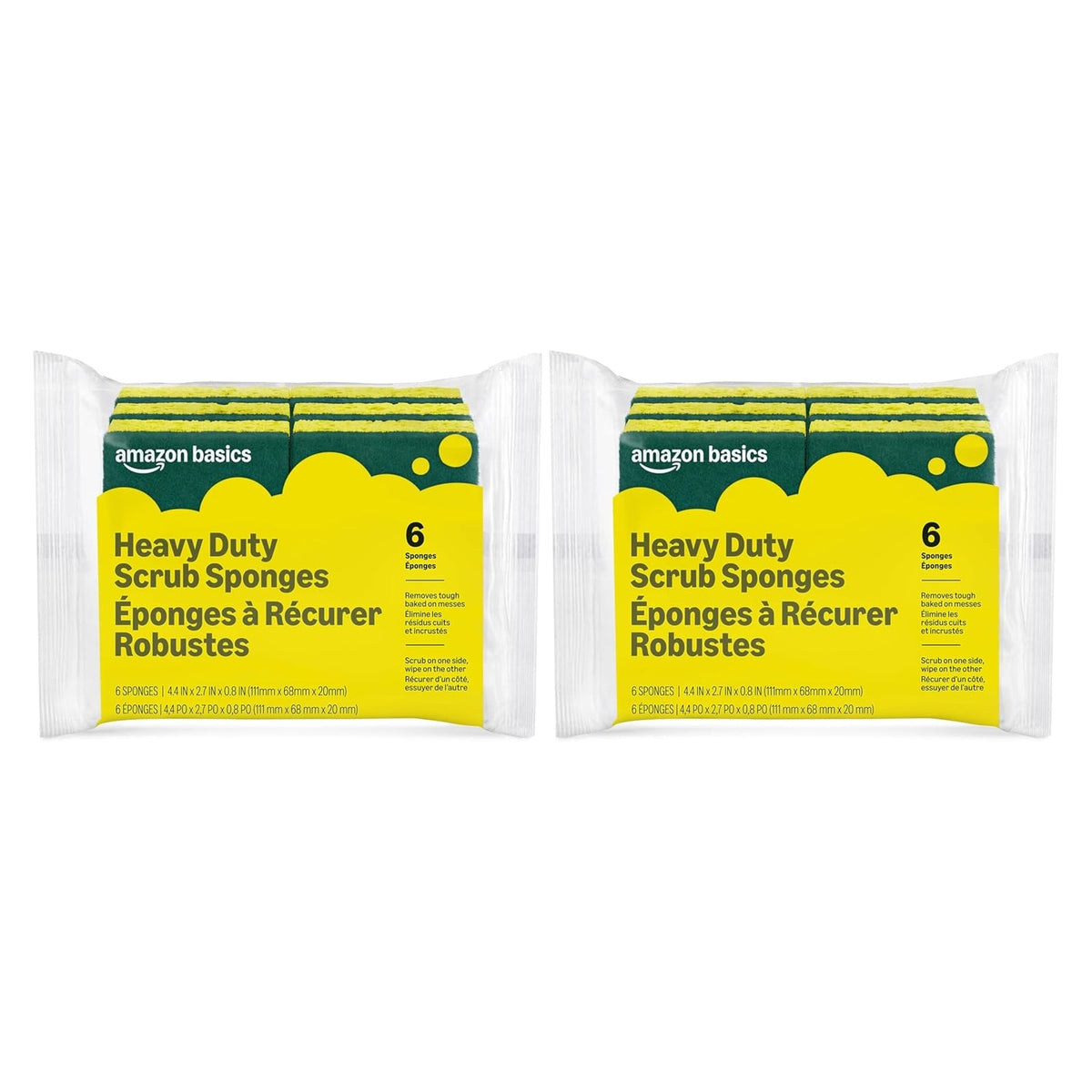 Two packs of Amazon Basics Heavy Duty Scrub Sponges in clear plastic wrap, each showing yellow sponges with green scrubbing pads stacked inside. Labels read '6 Sponges' per pack in green and yellow.