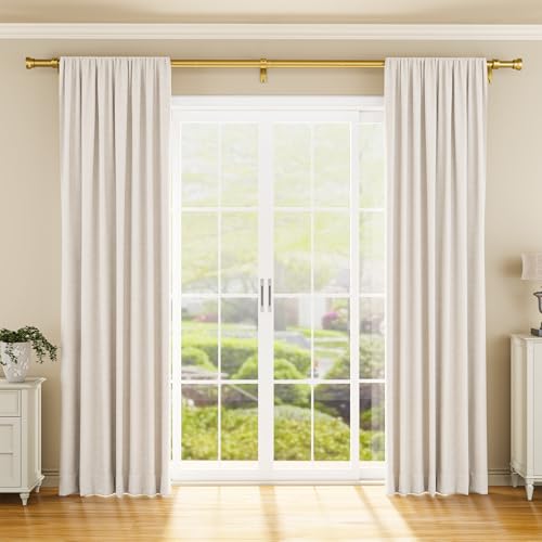 Gold curtain rod mounted above a large French door window, holding cream-colored drape panels. The rod features decorative finials and spans the full width of the window in a bright, neutral-toned room.