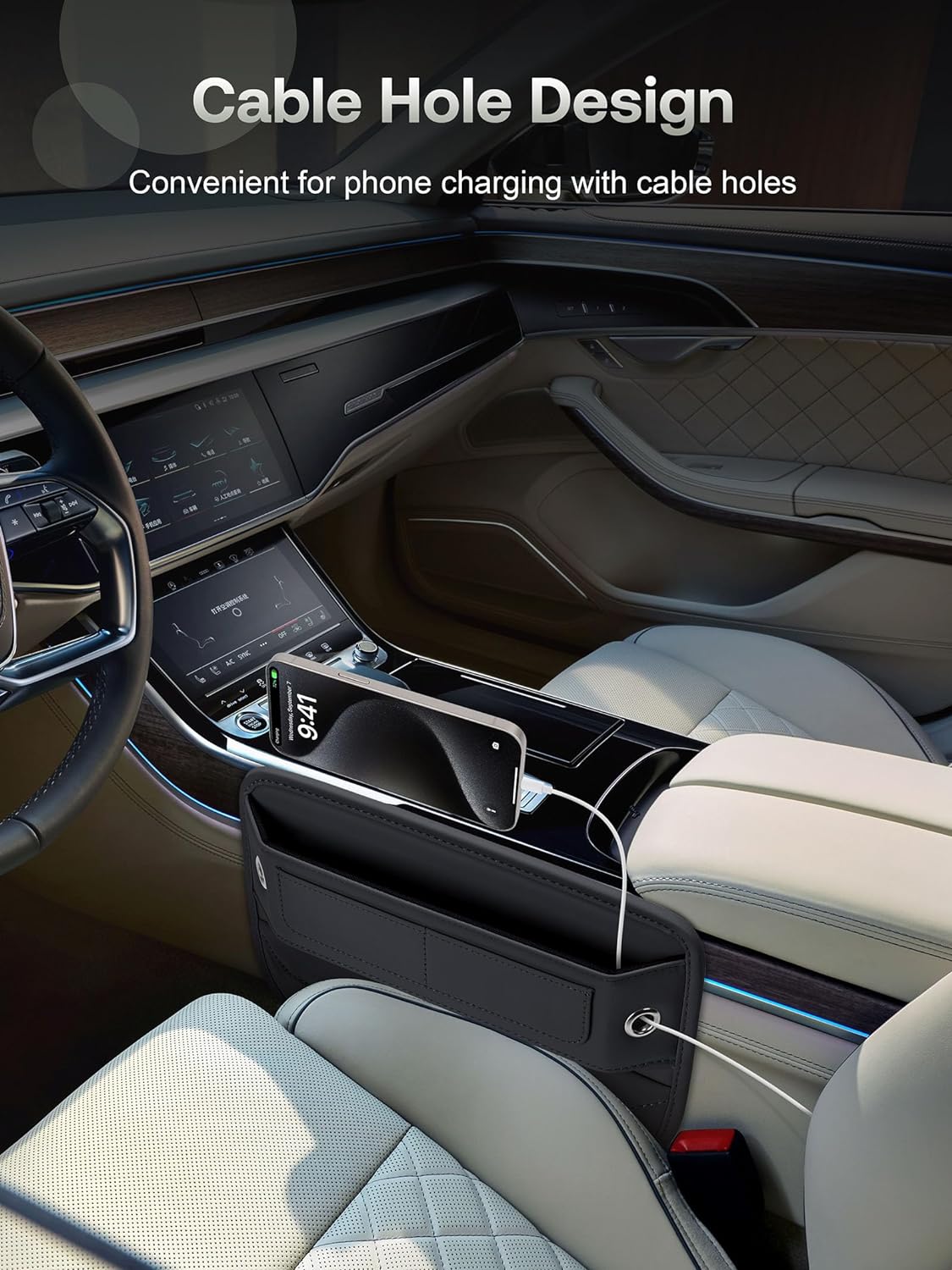 Black leather car seat gap filler organizer shown in a luxury car interior, positioned between the seat and center console. A phone displaying 9:41 is visible inside, with a charging cable routed through the organizer's cable hole.