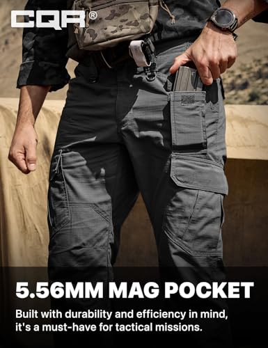 CQR tactical cargo pants in dark gray, shown on a person retrieving a magazine from a side mag pocket. Text reads '5.56MM MAG POCKET - Built with durability and efficiency in mind, it's a must-have for tactical missions.'