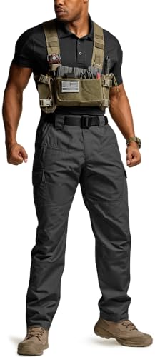 Man wearing dark gray tactical cargo pants with a black belt, paired with a tan tactical chest rig. Pants feature side cargo pockets and a straight fit. Shown with tan boots on a white background.