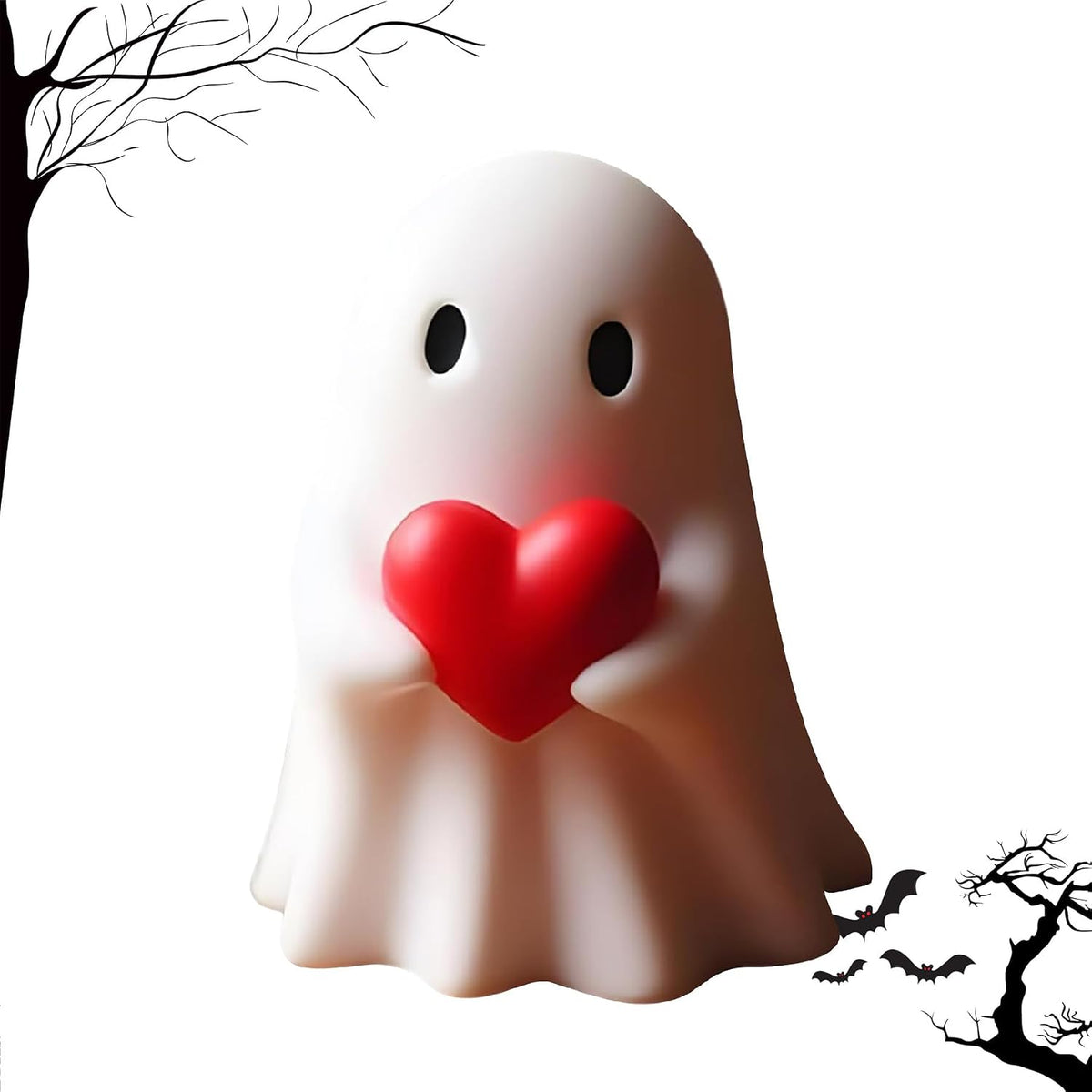 White resin ghost figurine with black oval eyes and rosy cheeks, hugging a red heart. Set against a white background with black silhouette bare trees and flying bats in the corners.