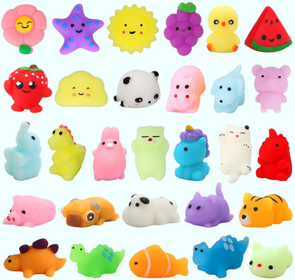 Collection of colorful kawaii-style squishy toys arranged in rows on a light blue background. Includes animal, food, and nature designs such as a flower, starfish, sun, grapes, chick, watermelon, strawberry, panda, unicorn, dinosaur, pig, dog, cat, fish, and more.