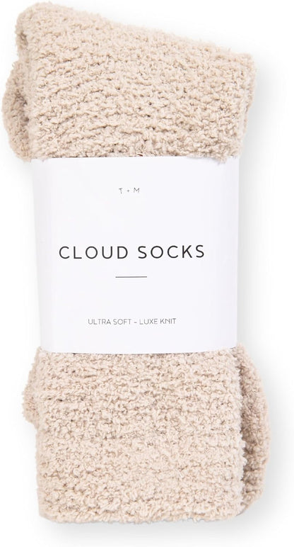 A pair of fluffy, textured beige socks folded and banded with a white label reading 'Cloud Socks' and 'Ultra Soft - Luxe Knit' with a T+M logo above.