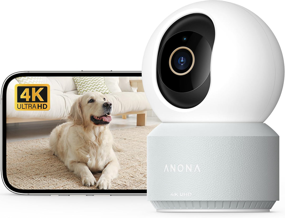 Anona 4K UHD indoor security camera with white dome-shaped head on a light gray textured base, shown beside a smartphone displaying a golden retriever in 4K Ultra HD.