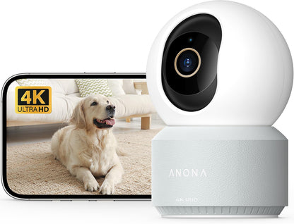 Anona 4K UHD indoor security camera with white dome-shaped head on a light gray textured base, shown beside a smartphone displaying a golden retriever in 4K Ultra HD.