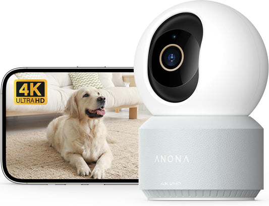 Anona 4K UHD indoor security camera with white dome-shaped head on a light gray textured base, shown beside a smartphone displaying a golden retriever in 4K Ultra HD.