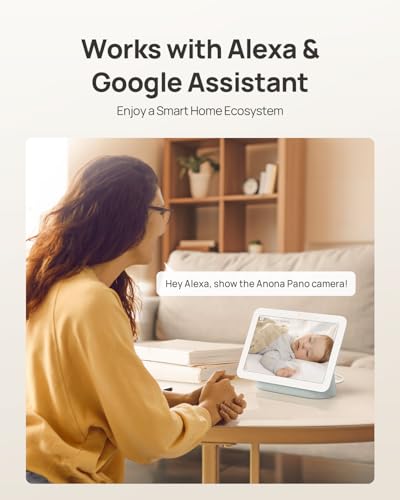 Promotional banner stating 'Works with Alexa & Google Assistant' and 'Enjoy a Smart Home Ecosystem.' A woman in a yellow sweater sits at a desk viewing a smart display showing a sleeping baby, with a speech bubble reading 'Hey Alexa, show the Anona Pano camera!'